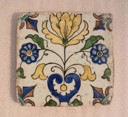 Tegel met decor van gestileerde tulp in vaas en Franse lelies in hoeken